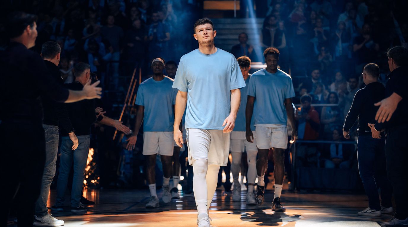 Basketballspieler beim Korbleger gegen einen Verteidiger, im Hintergrund Zuschauer in einer Halle
