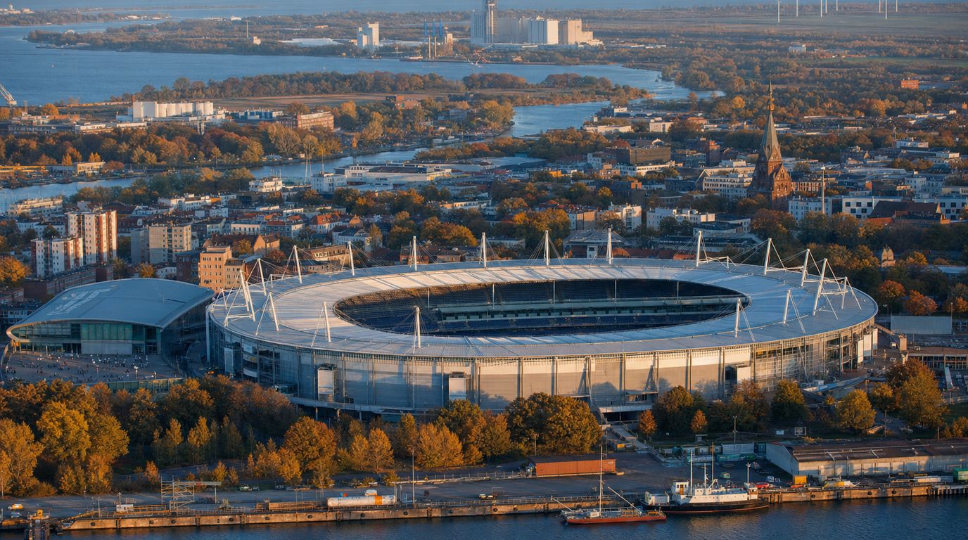 Blick über die Rostocker Innenstadt im Herbst mit beleuchteter Sporthalle am Abend